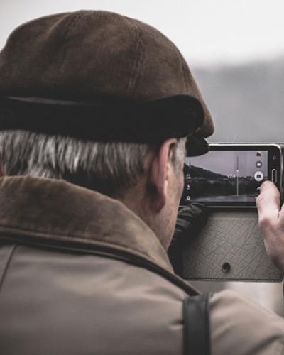 Older man taking photo with phone